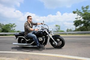 A young man riding a motorcycle on an open road