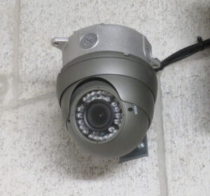 A security camera is securely mounted on a wall, monitoring the area for safety and surveillance purposes.