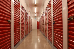 A long hallway featuring red doors against a backdrop of pristine white walls, creating a striking visual contrast.